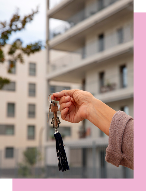 klucze do nowego mieszkania w Słupcy trzymane na tle nowoczesnego bloku