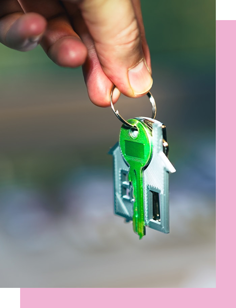 Zbliżenie na dłoń trzymającą zielony klucz oraz brelok w kształcie domu, co symbolizuje pomyślny zakup nieruchomości w Giewartowie lub Powidzu. Zdjęcie wykonane dla biura Royal Invest, podkreślające bezpieczeństwo i radość z nabycia własnego lokum nad Jeziorem Powidzkim