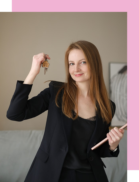 Portret studyjny uśmiechniętej kobiety z jasnobrązowymi włosami, w czarnej marynarce i topie z koronką. Trzyma w prawej ręce uniesiony zestaw kluczy, a w lewej mały czarny folder.